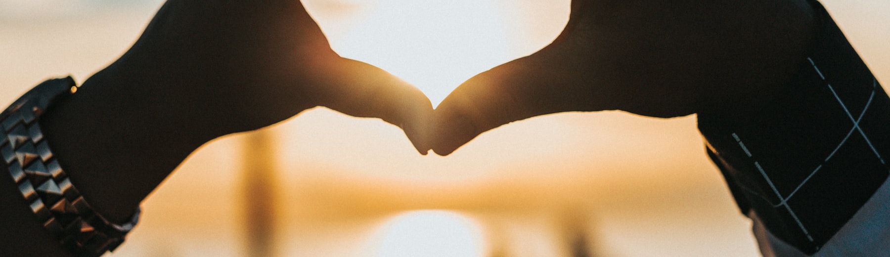 Two hands lightly clasped in warm light, suggesting closeness and trust